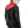 (Front): Photo of a model wearing a black leather jacket. The jacket is a motorcycle cut with a red hood and a red leather lining that is visible inside the cuffs and the folded down collar. There is also a strip of red leather either side of the front zipper. Where breast pockets typically would be on a jacket, there are [handpainted/patched] green eyes surrounded by white details. The collar has metal pop buttons to hold it in place. (Back): Photo of the same black leather jacket with a red hood. The jacket is a motorcycle cut. The inside of the hood has a mesh lining.