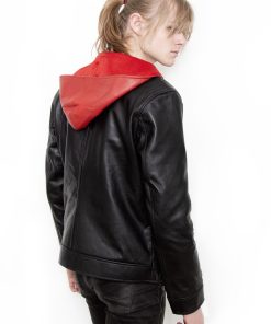(Front): Photo of a model wearing a black leather jacket. The jacket is a motorcycle cut with a red hood and a red leather lining that is visible inside the cuffs and the folded down collar. There is also a strip of red leather either side of the front zipper. Where breast pockets typically would be on a jacket, there are [handpainted/patched] green eyes surrounded by white details. The collar has metal pop buttons to hold it in place. (Back): Photo of the same black leather jacket with a red hood. The jacket is a motorcycle cut. The inside of the hood has a mesh lining.